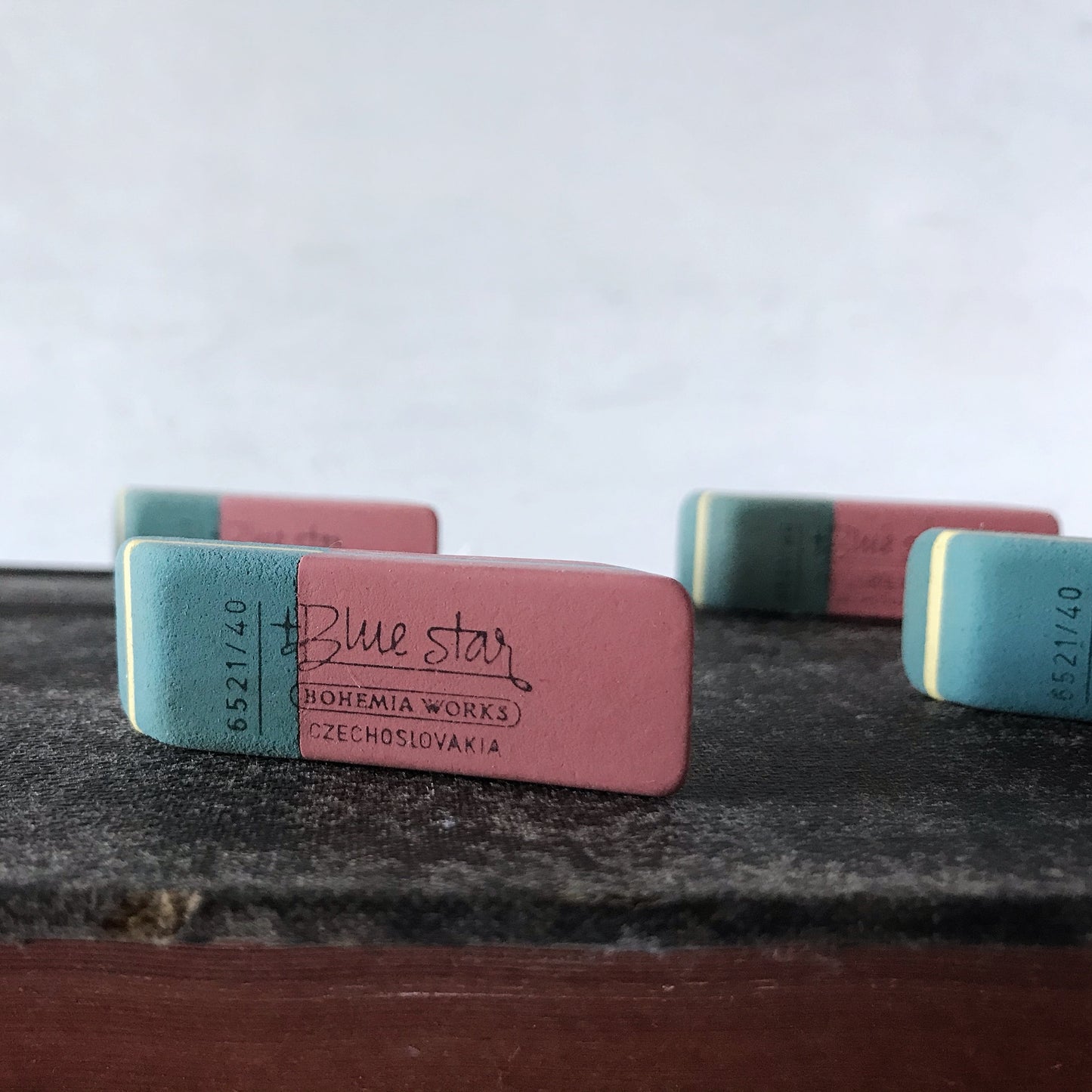 Two erasers with 'Blue Star' branding on a textured surface