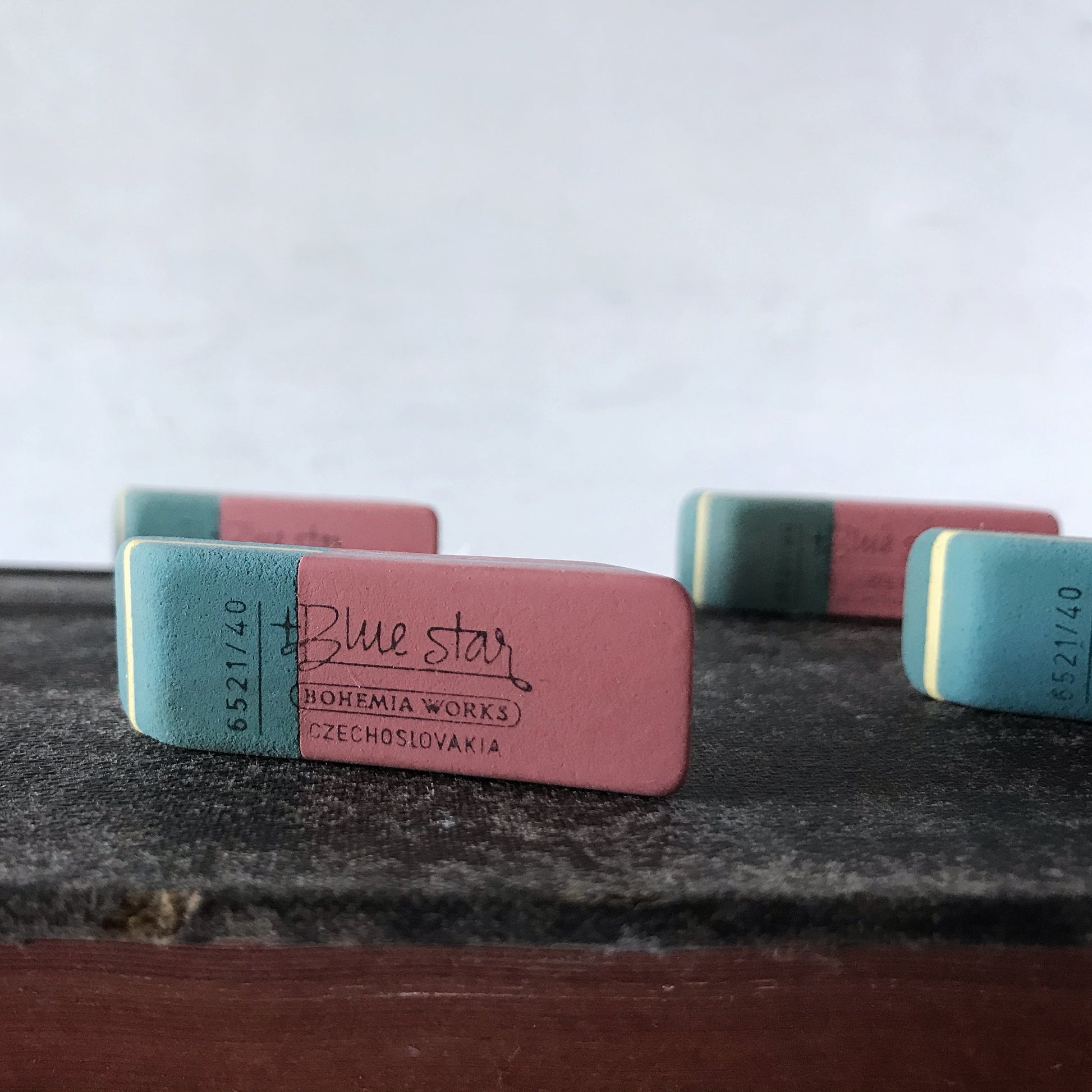 Two erasers with 'Blue Star' branding on a textured surface