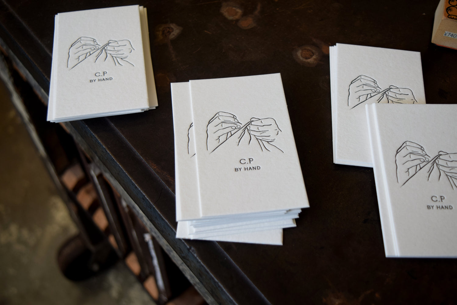 Stacks of white cards with black text and illustrations on a dark wooden surface