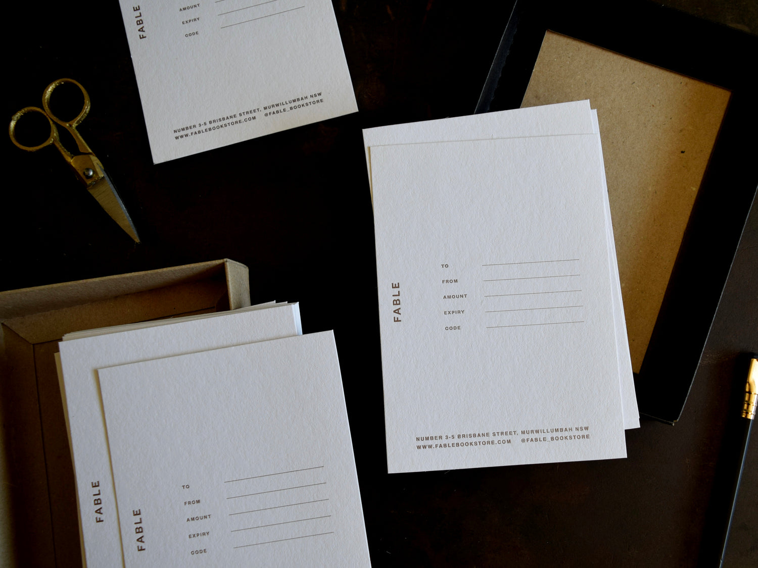 White stationery items with 'Fable' branding on a dark surface.