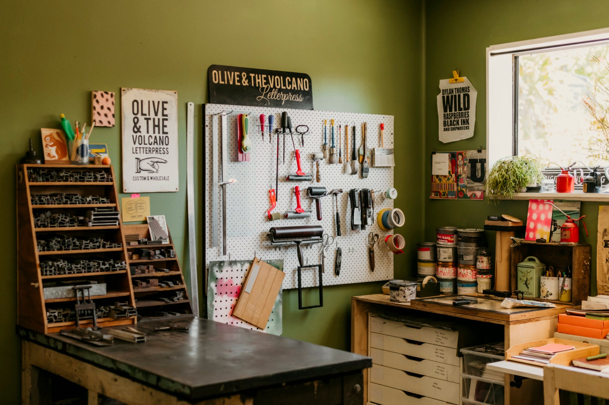 Workshop or craft room with tools on a pegboard, shelves, and a desk.