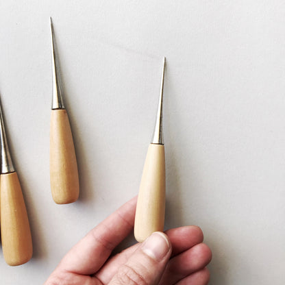Set of three carving tools with wooden handles on a light background