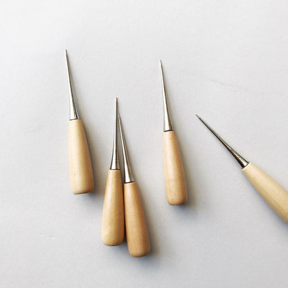 Set of four wooden-handled tools with metal tips on a light gray background